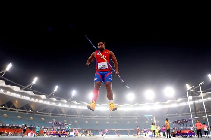 Athlete mid-air with javelin during night event at Siena International Photo Awards 2026