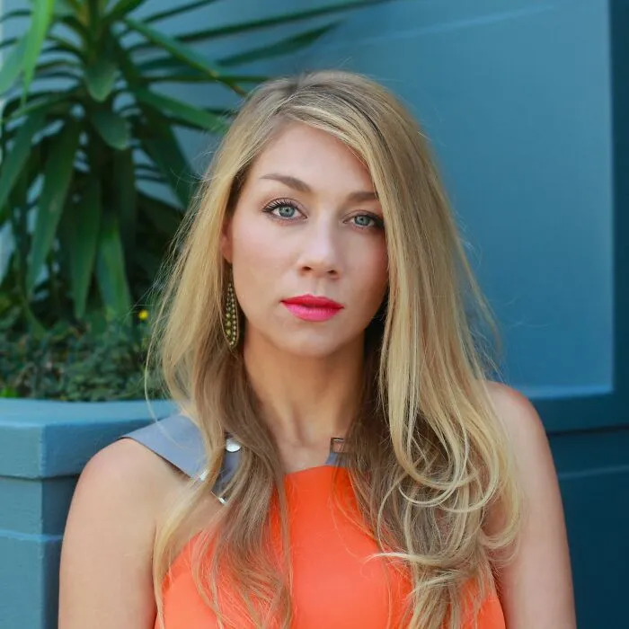 Portrait of a blonde woman wearing an orange top, illustrating behaviors they refuse to tolerate.