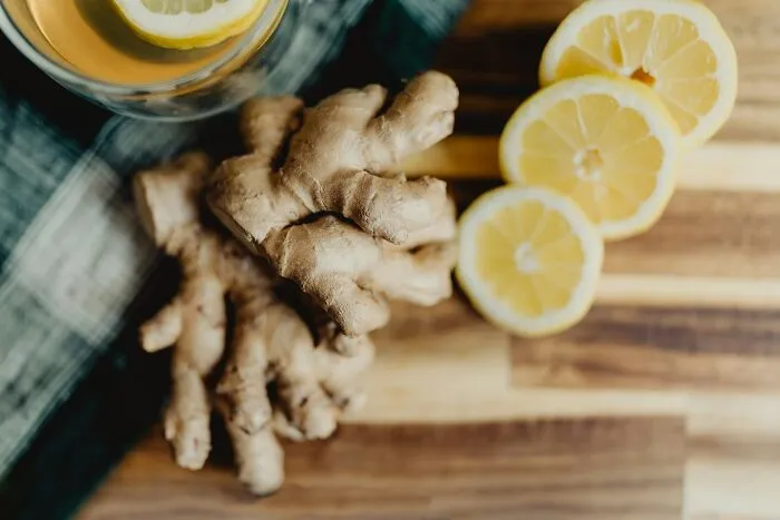 Fresh ginger roots and sliced lemons on a cutting board, sharing brilliant tips for herbal remedies.