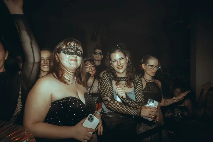 A group of people wearing costumes and masks at a crowded party during Halloween conflicts.