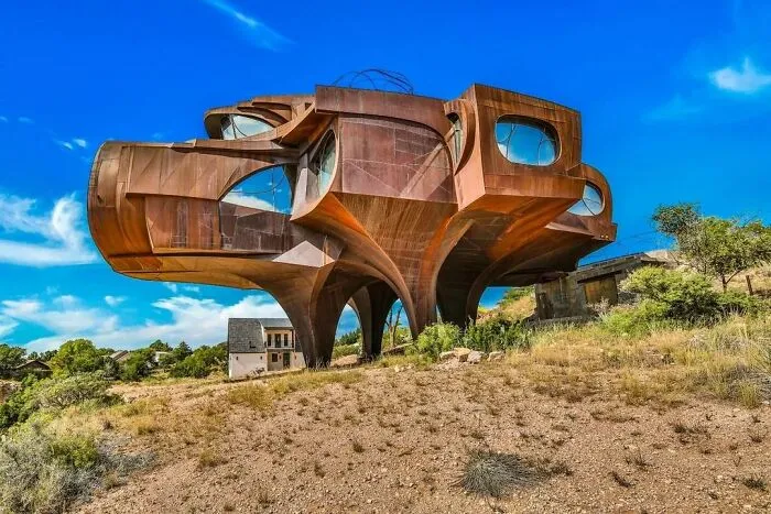 Futuristic strange building with curved metal structure on hillside