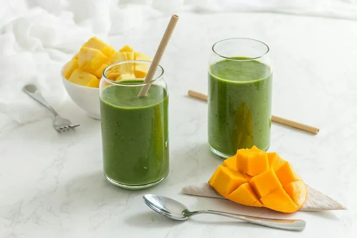 Fresh green smoothies and chopped mango representing food brands consumers refuse to give money to