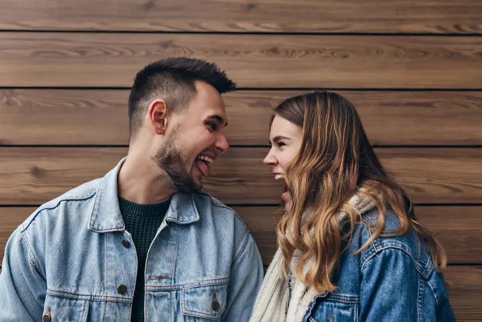 Playful couple in denim jackets sharing a moment before wedding
