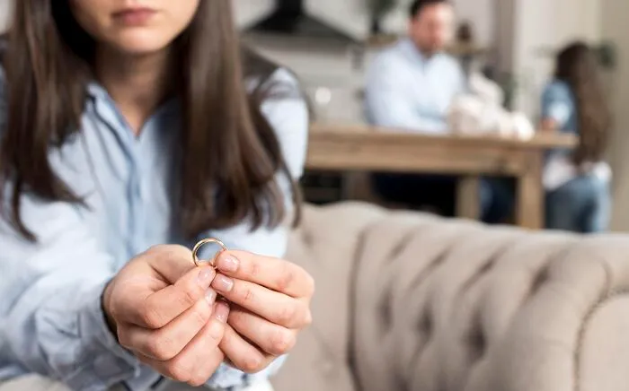 Woman holding wedding ring contemplating divorce advice