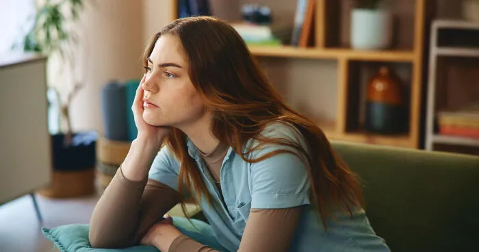 A thoughtful woman looking away, pondering intelligent insults that are hard to spot