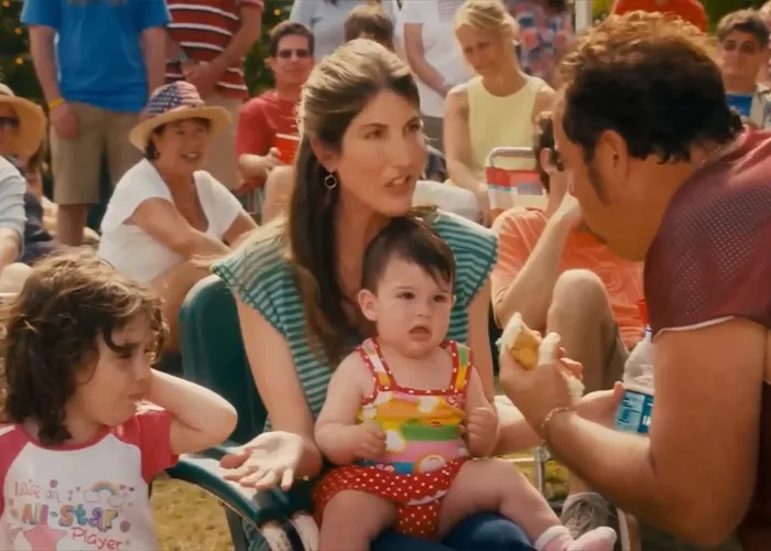 Adam Sandler relaxing outdoors in lawn chairs with cast members from his films.