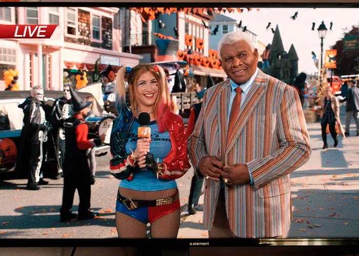 Adam Sandler pointing ahead next to Julie Bowen in a film scene