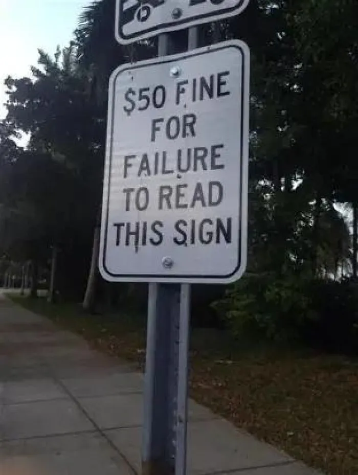 Absurd signs along a sidewalk reading 50 dollar fine for failure to read this sign