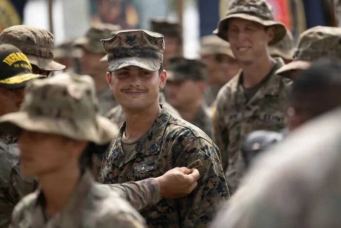 Smiling soldier receiving a patch in uniform, staying calm despite fight-or-flight feelings