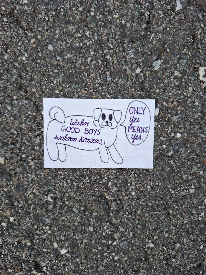A hand-drawn dog on a piece of found paper placed on asphalt with a speech bubble saying ONLY Yes MEANS Yes.