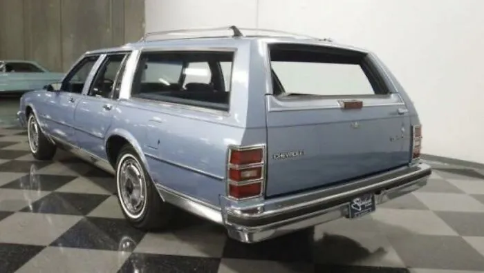 Vintage blue Chevrolet station wagon parked inside, captured in nostalgic photos for 80s kids childhoods.