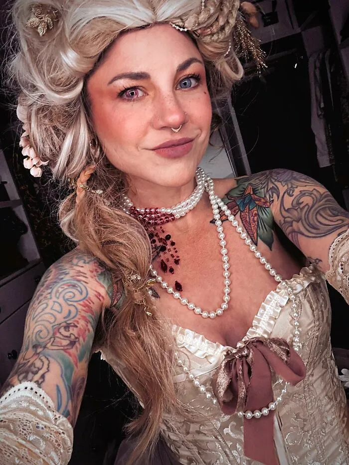 A woman styled as Marie Antoinette featuring creative Halloween costume ideas with a corset and pearl necklace.
