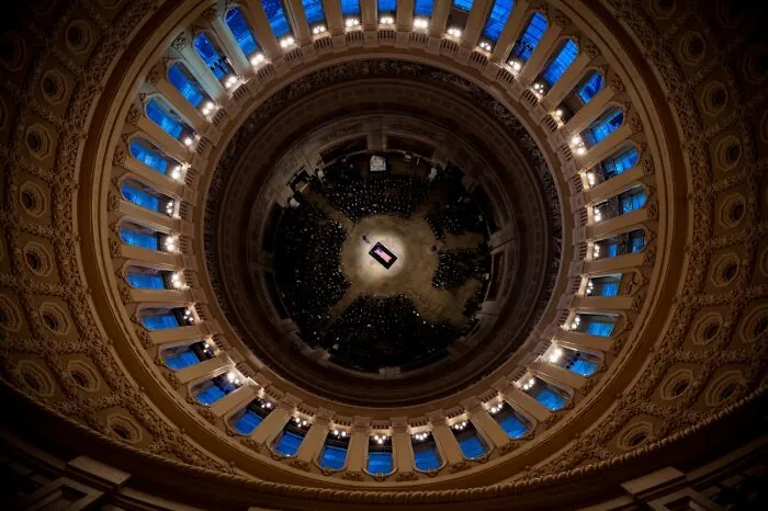 Interior dome view from below at a crowded event with architectural details and blue window lighting