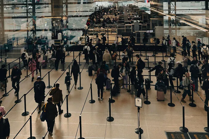 Busy airport terminal with travelers standing in long security lines illustrating petty revenge stories