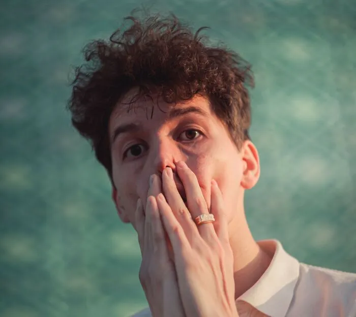 Person covering mouth in surprise, representing microaggressions awareness