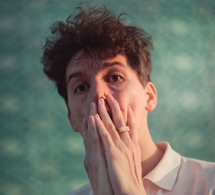 A shocked man with hands over his face reflecting on a costly slip-up.