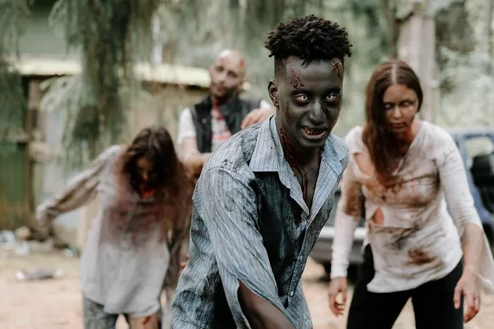 Spooky zombies walking outdoors, depicting Hollywood horror movie tropes.