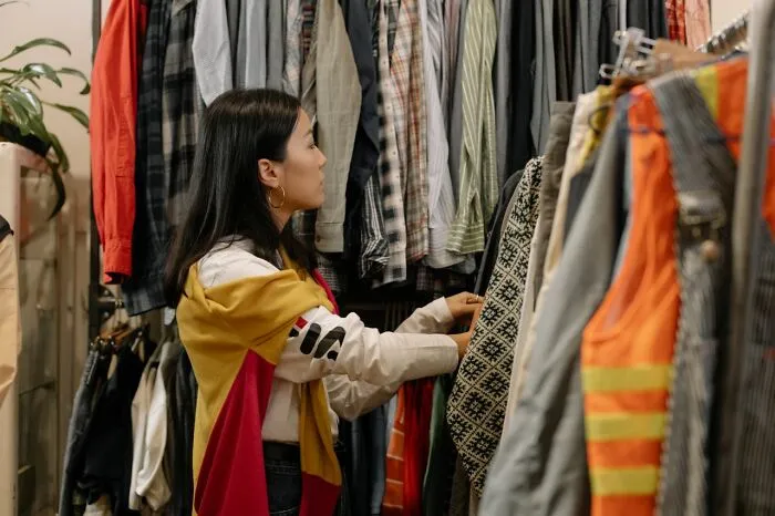 A woman browsing clothing on a rack using clever life tricks for shopping