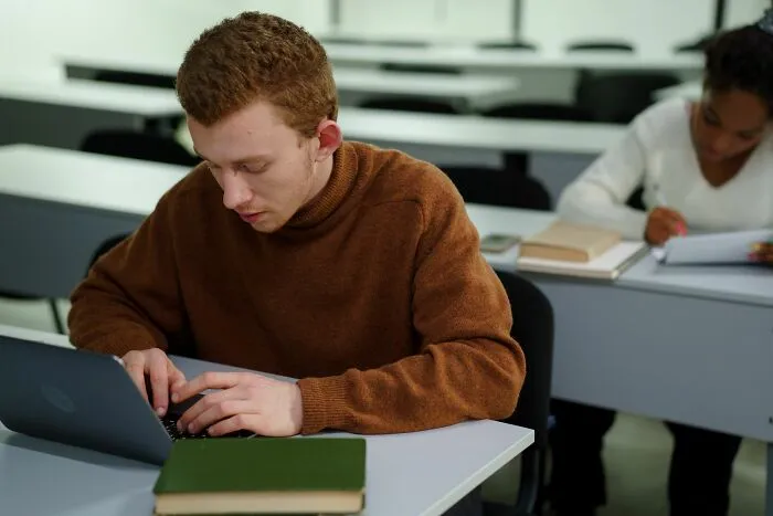 A student working on a laptop in a classroom related to strange laws and loopholes