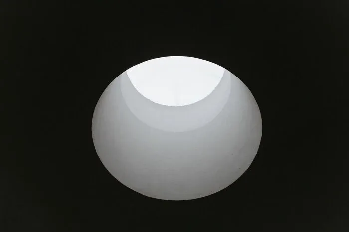 A white circular hole opening in a solid black background, reminiscent of a mysterious school rumor