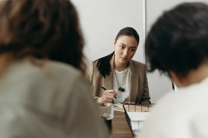 A focused professional listening in a meeting, using clever life tricks for better office communication