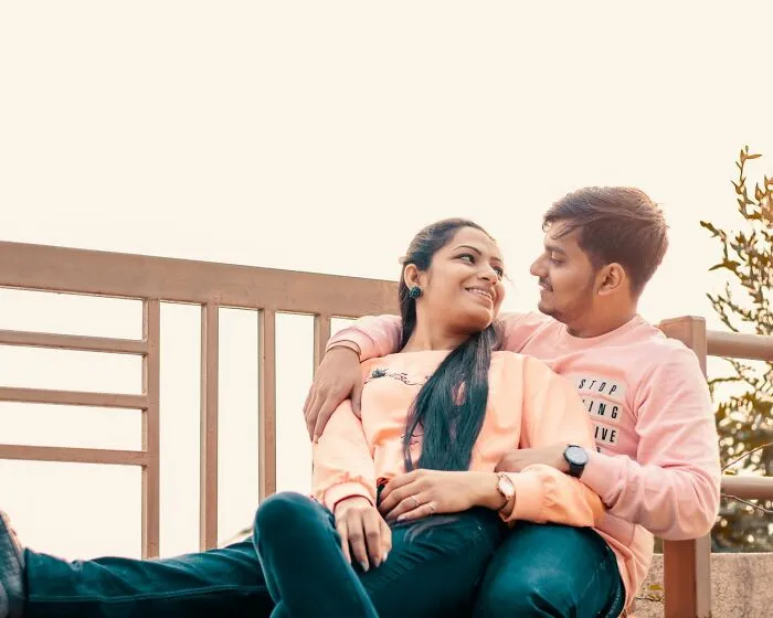 A happy couple sitting outdoors applying clever life tricks for a picture