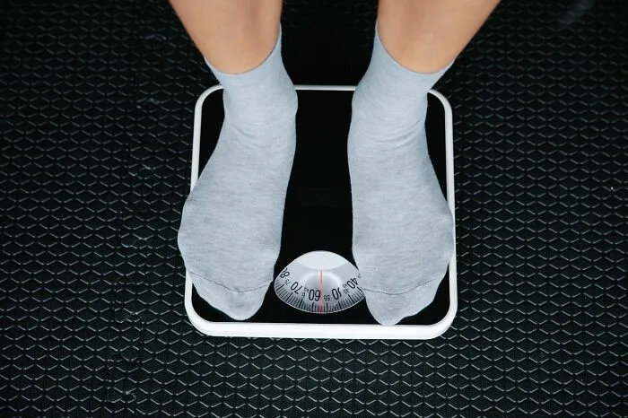 Top view of a person standing on a scale, capturing a funny moment