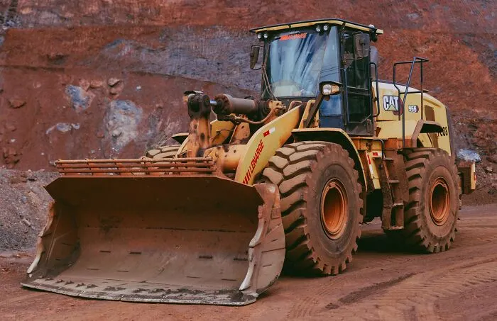 A large yellow excavator at a construction site, tied to chilling stories of instincts and safety.