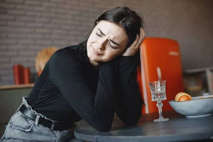 A frustrated woman leaning on a table, representing how dumb things professionals said cause clients to lose trust