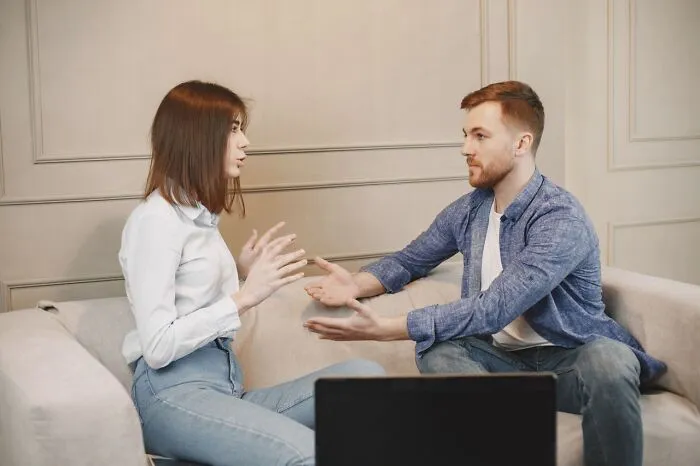 A couple having an intense conflict while sitting on the couch during Halloween
