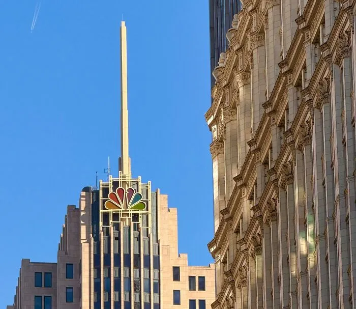 The NBC logo on a tall city building, representing media companies consumers refuse to support