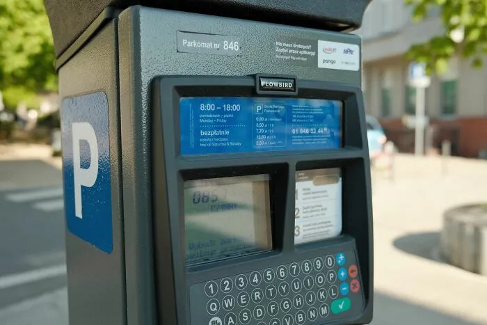 A parking meter machine on the street, illustrating unethical life pro tips about parking fees