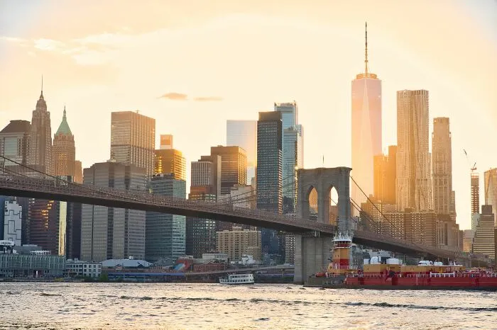 The Brooklyn Bridge and New York City skyline at sunset, showing a typical movie setting to highlight Hollywood tropes.