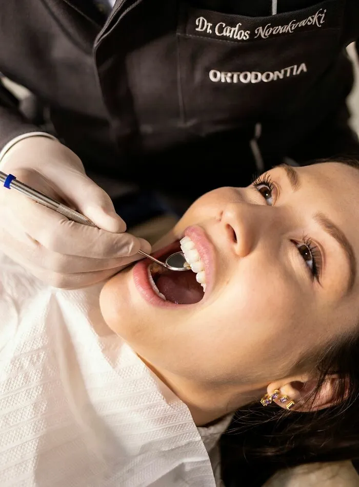 A dentist checking a patient teeth with a dental mirror as part of clever life tricks for personal care.