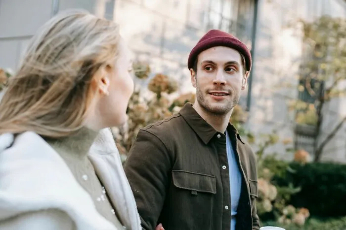 Man smiling and talking outdoors with woman about microaggressions