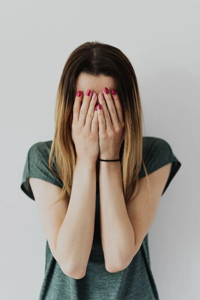 Woman covering her face with hands, illustrating embarrassment and frustration