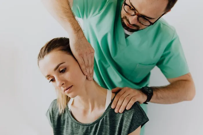 A physical therapy professional examining a client neck, showing trust in healthcare