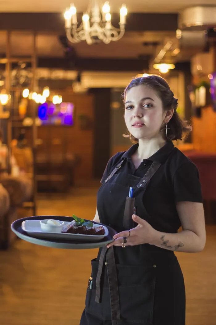 Waitress holding a tray calmly amid Karen confrontation