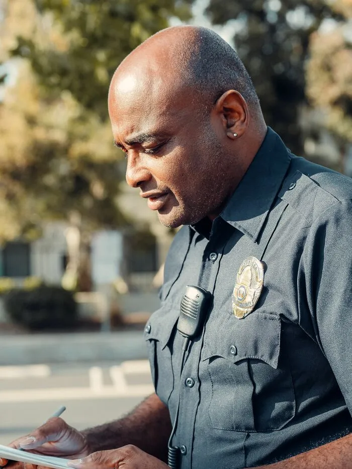 Police officer taking notes outdoors representing enforcement of strange legal loopholes