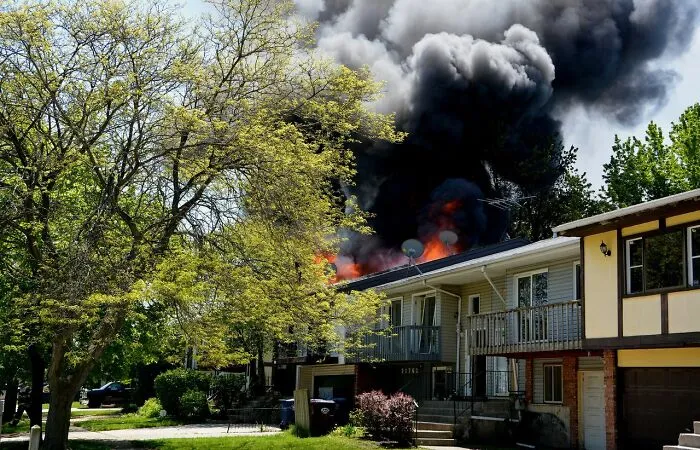 A house engulfed in fire with heavy black smoke, showing an obvious need to leave immediately