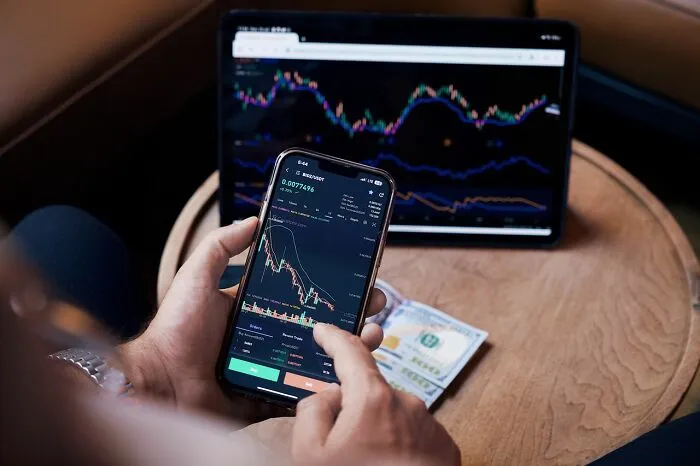 A person tracking financial charts on a smartphone, using clever life tricks for smart investing