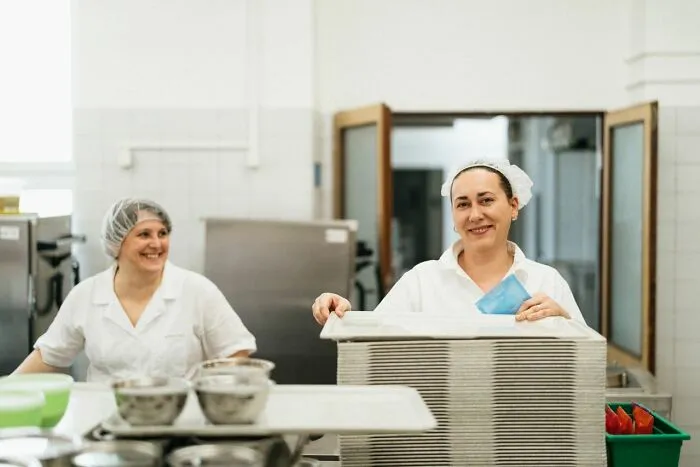 School cafeteria staff smiling in a kitchen, reflecting common school rumors about lunch ladies