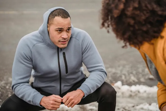Man in a hoodie engaged in a serious conversation about microaggressions women report