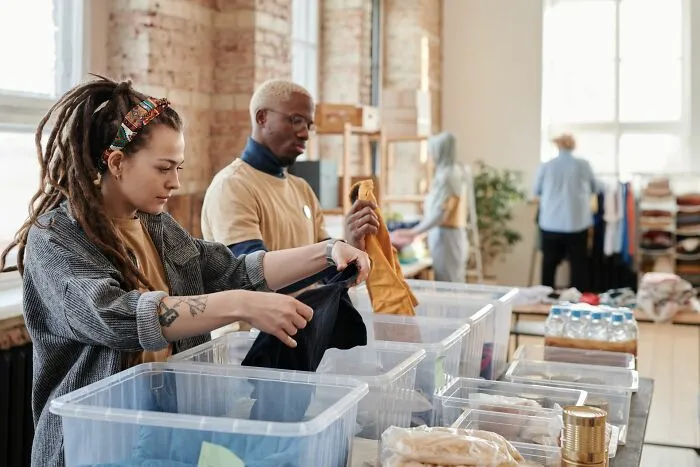 Volunteers organizing clothes in donation bins to make everyday life easier for those in need.