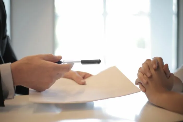 Person holding a pen over a document during a meeting showcasing clever life tricks for success