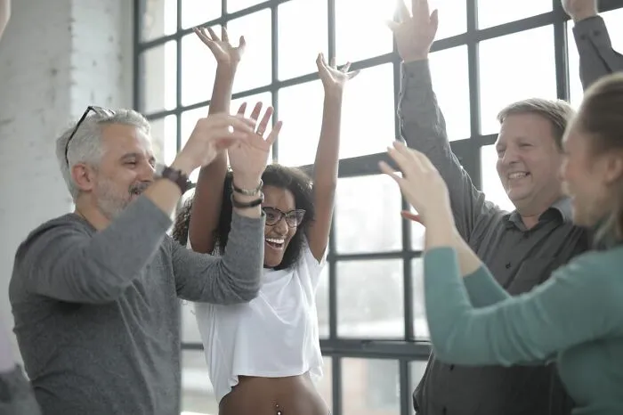 A group of colleagues celebrating together, showing clever life tricks for boosting workplace morale