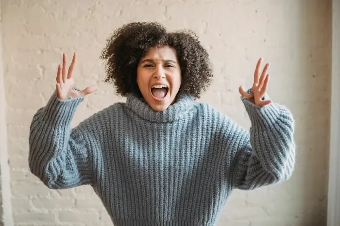 Woman expressing frustration about Karens in grey sweater