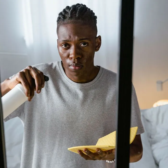 Man cleaning mirror, symbolizing reflection on microaggressions