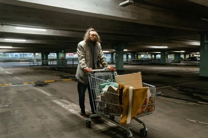 Man in a parking lot with a shopping cart with an urgent feeling to leave