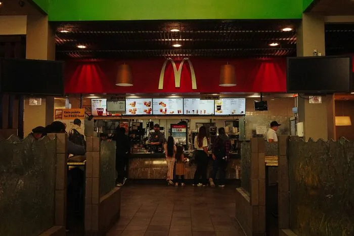 Customers ordering food at a McDonald's counter, one of the companies people refuse to support.